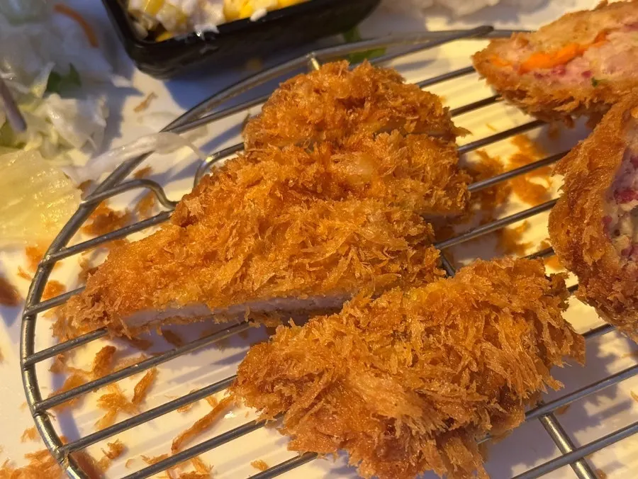 A piece of cheese katsu with cheese pouring out