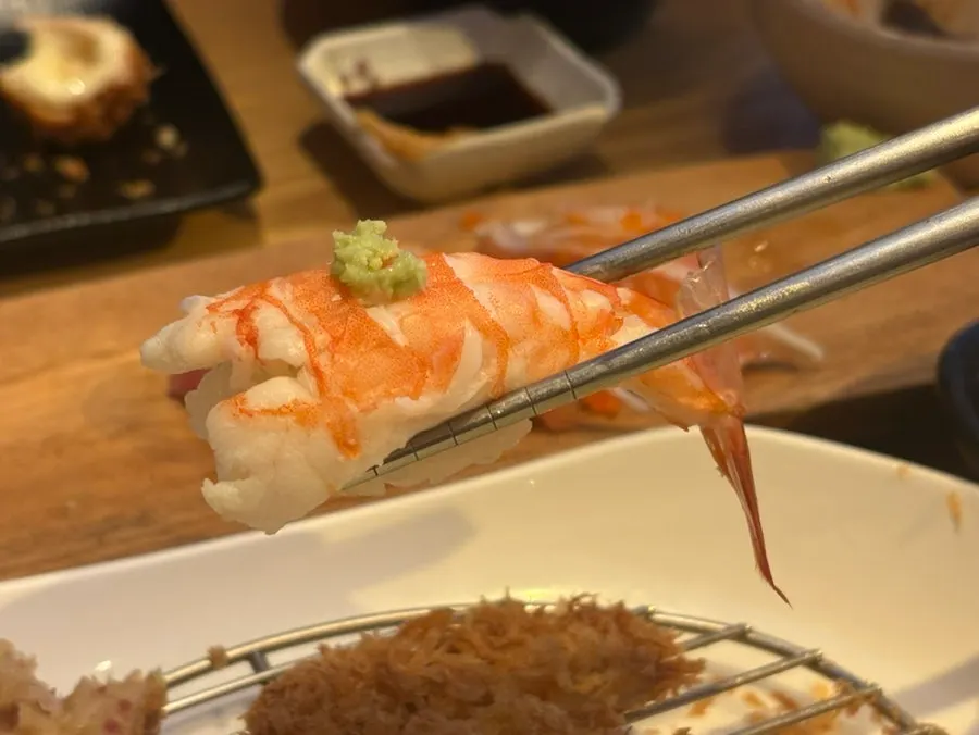 A sushi plate with flounder, tuna, and eel on top