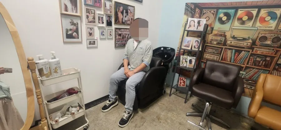 Photo zone wall with the Suspicious Hair Salon poster