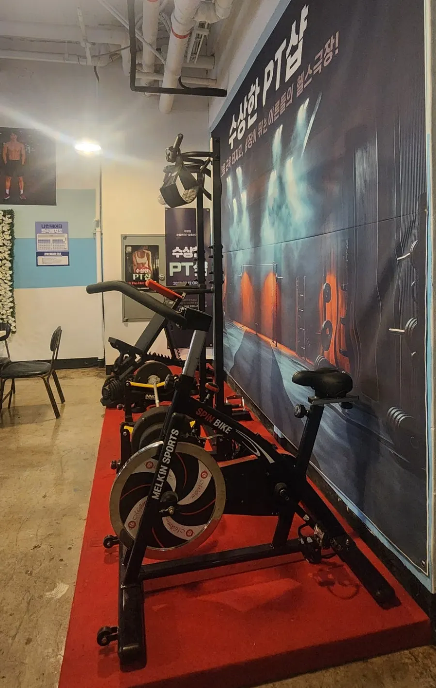 PT-gym-themed photo zone with a styrofoam barbell