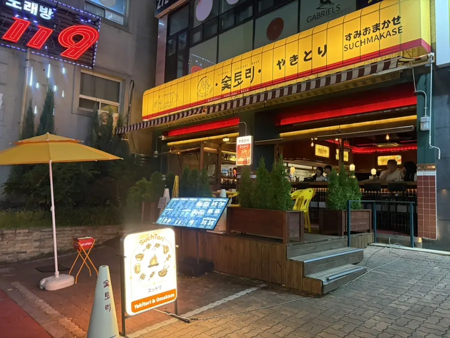 Sutori's entrance with soft lighting and neon signs