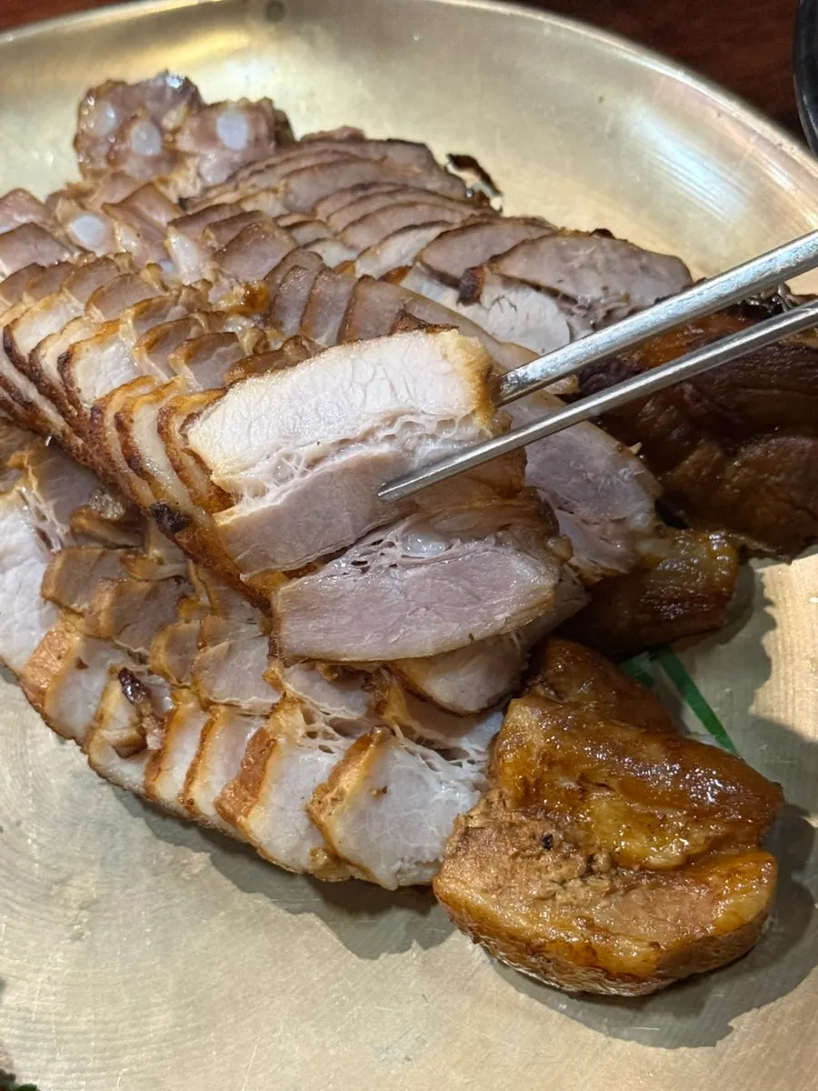 Thick-sliced charcoal-grilled bossam meat served in a brass bowl