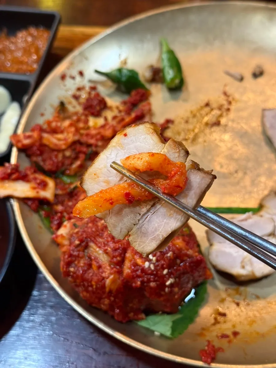 A piece of bossam meat wrapped with garlic chives