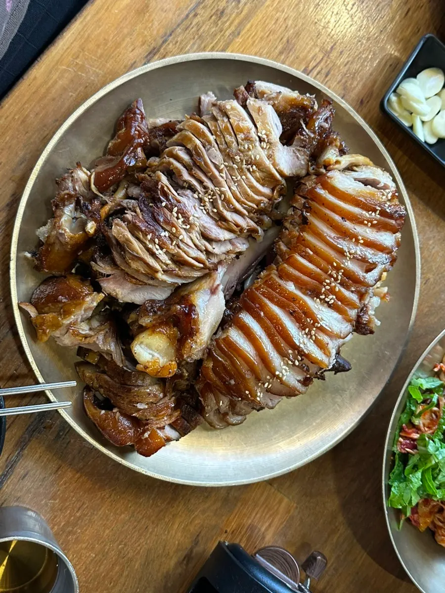 A full table of charcoal-grilled jokbal and bibim makguksu
