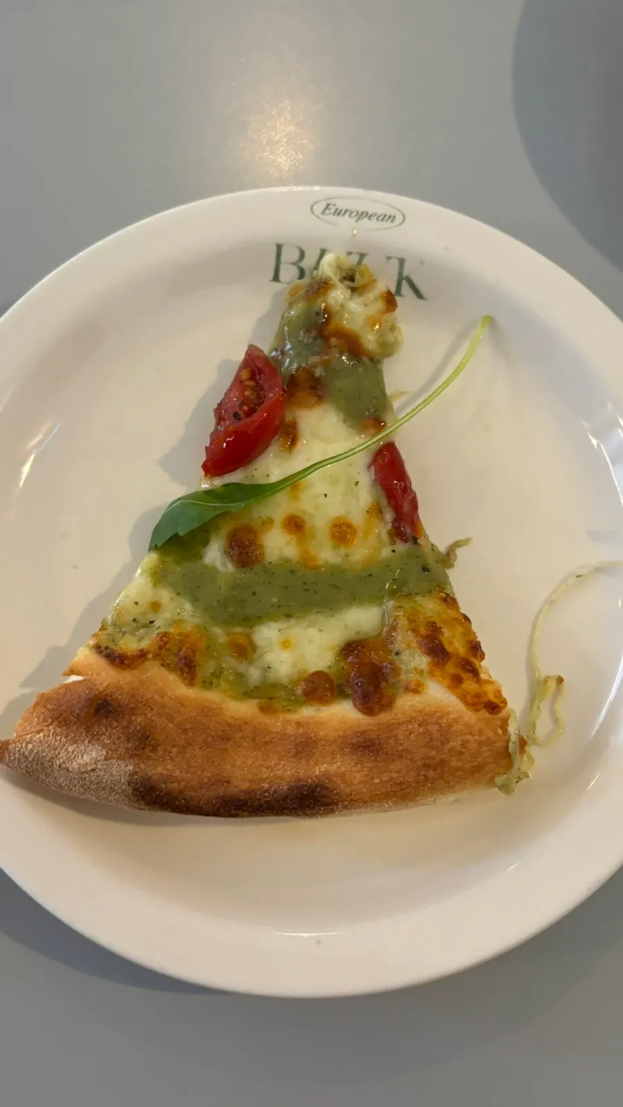 Pizza with basil pesto and tomatoes