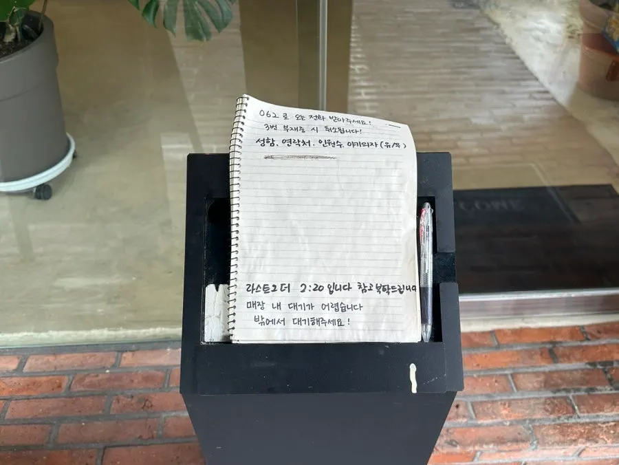 Waiting-list notebook notice in front of the restaurant