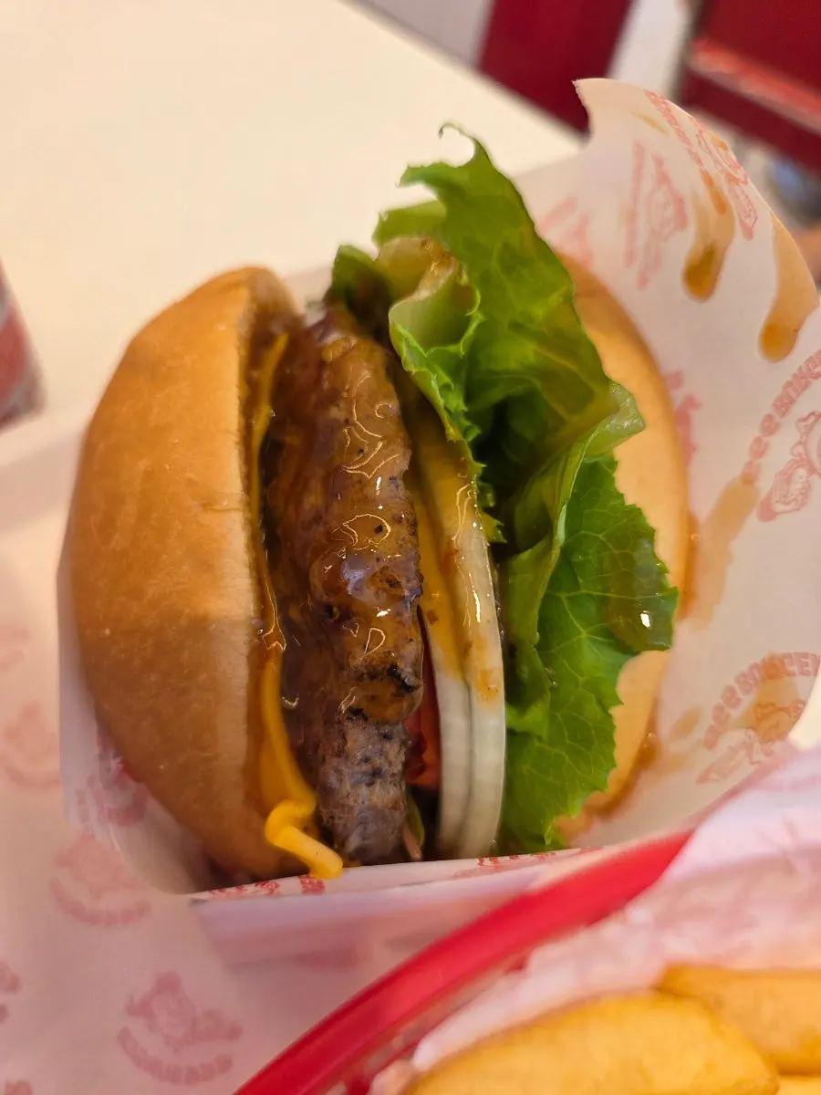 Burger buatan tangan 666 Burger dipegang dengan satu tangan