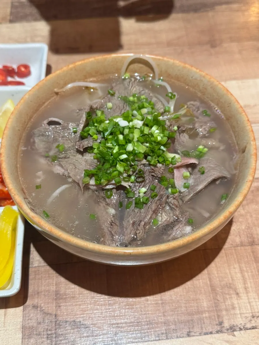 A spoonful of the rich beef brisket pho broth