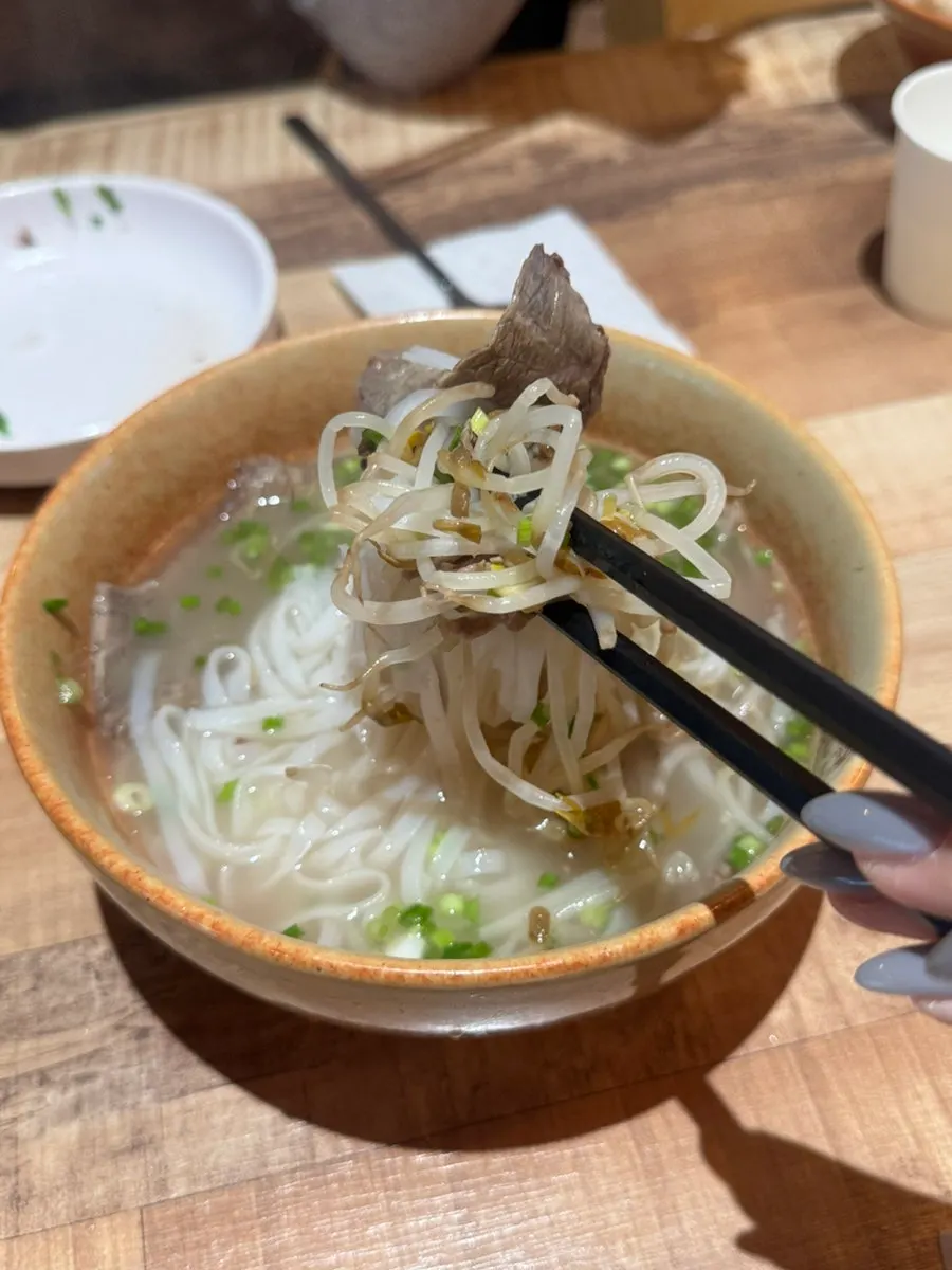 Lifting noodles from the beef brisket pho
