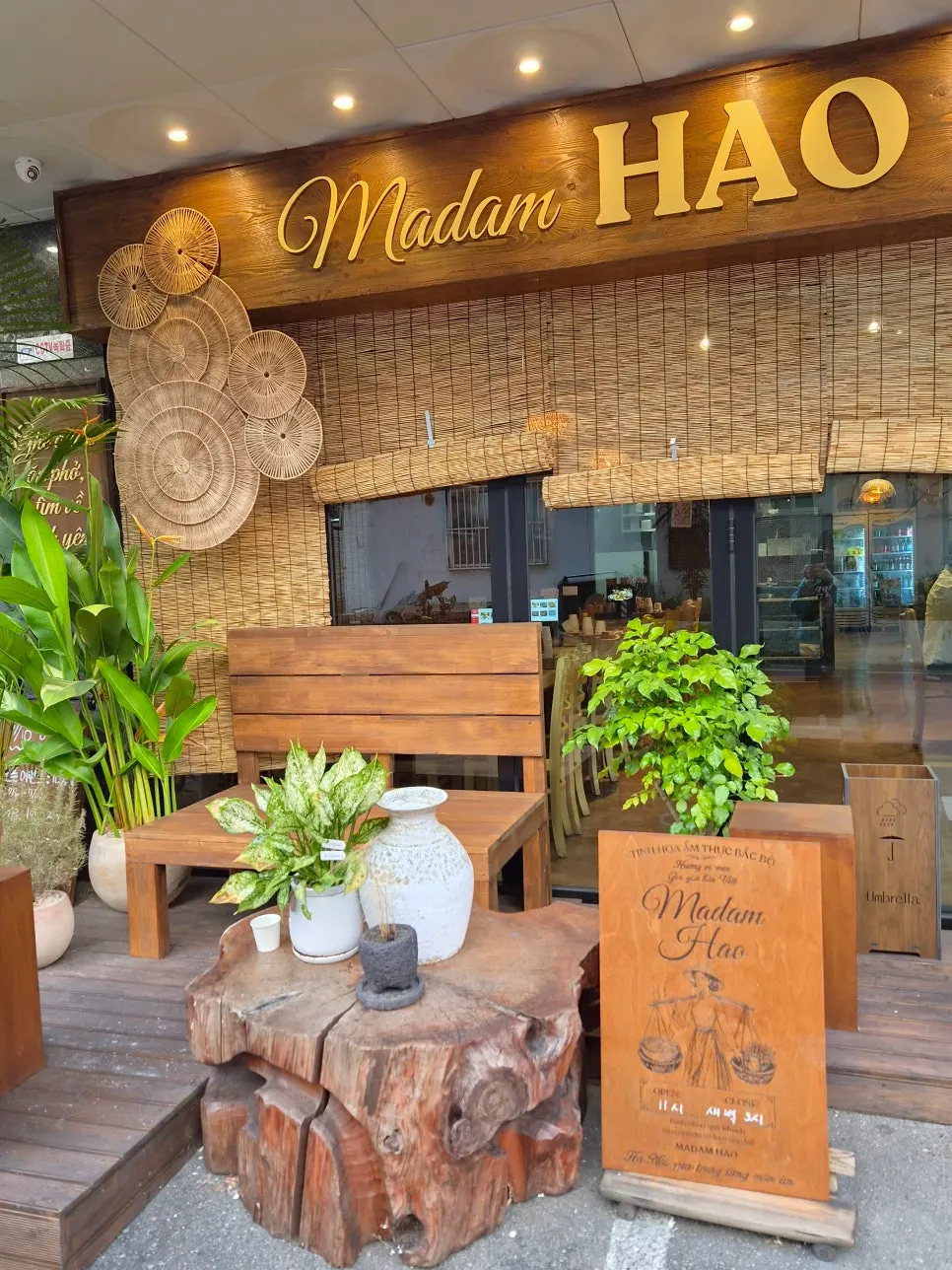 A corner of the restaurant with green plants and Vietnamese-style props