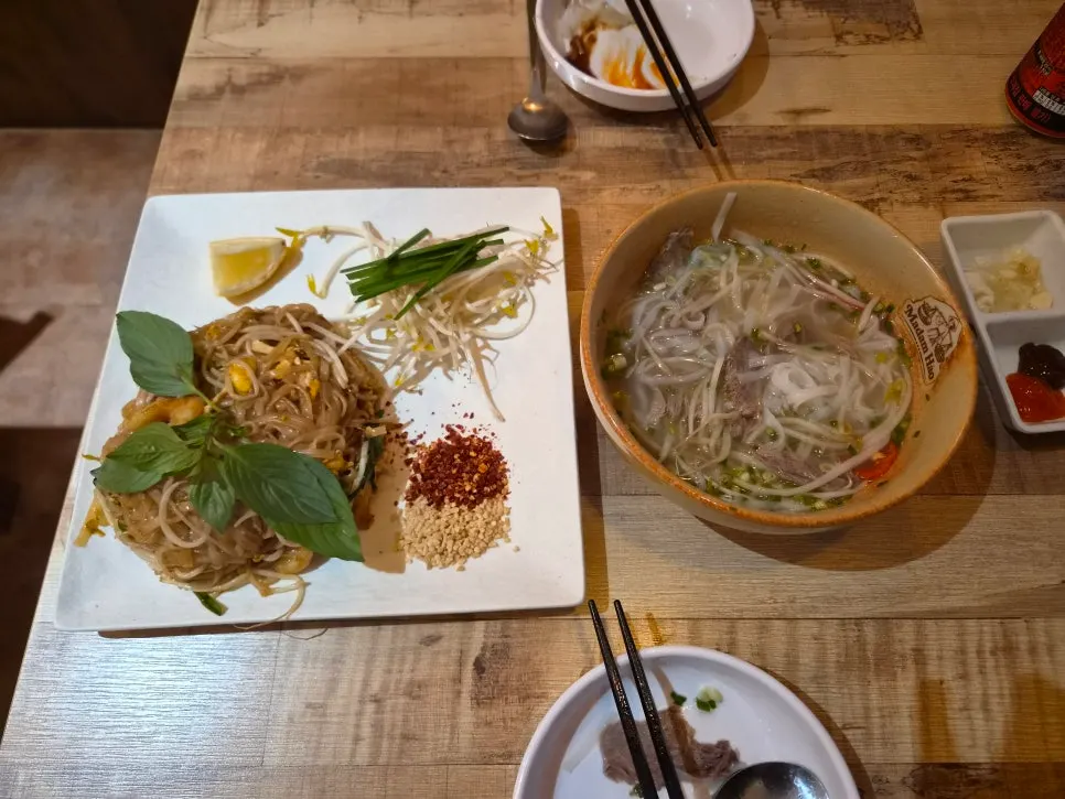 Table set with both the pho and the pad thai together