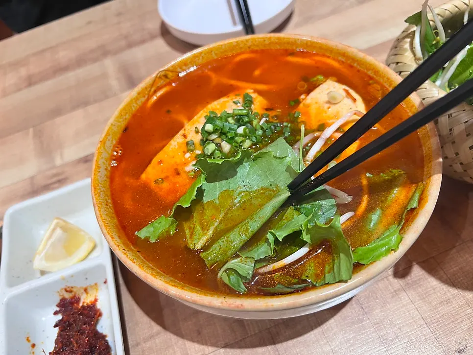 Fresh herbs served alongside bun bo Hue