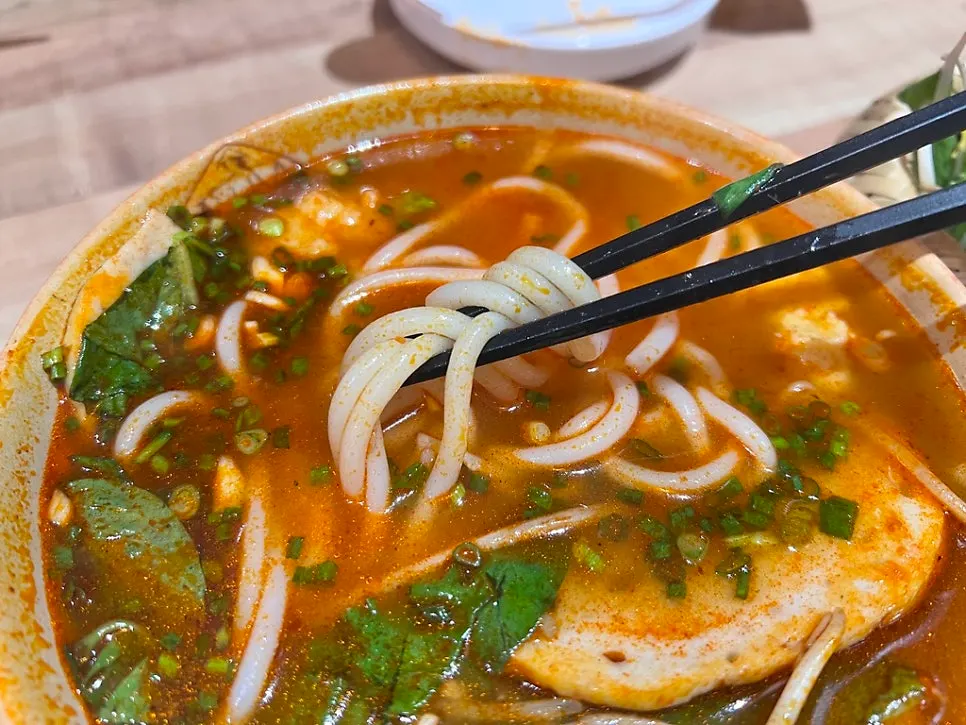Bun bo Hue with blood cake, fried tofu and fish cake toppings