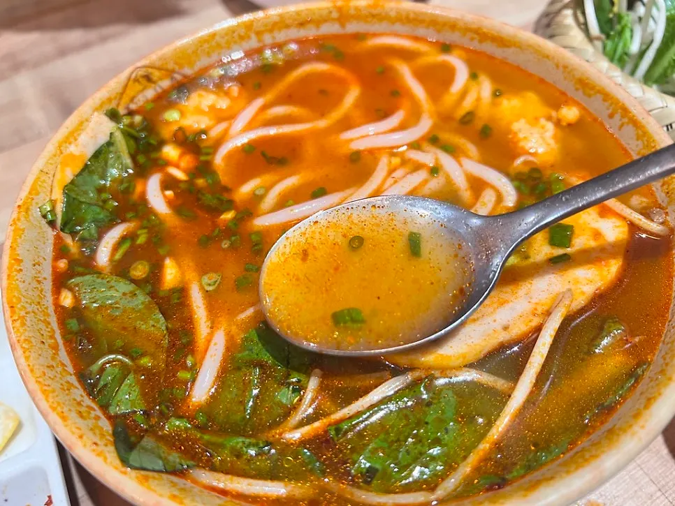 Chewy round pho noodles lifted from the bowl