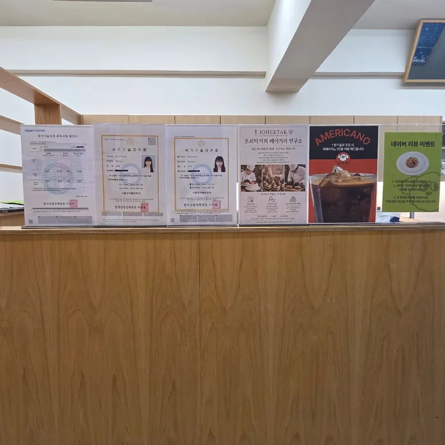 Menu board listing coffee, non-coffee, tea, and cake