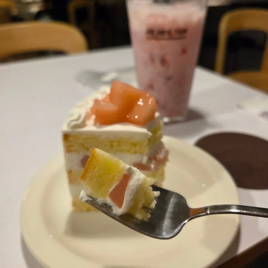 Side view of cake topped with peach and yogurt cream