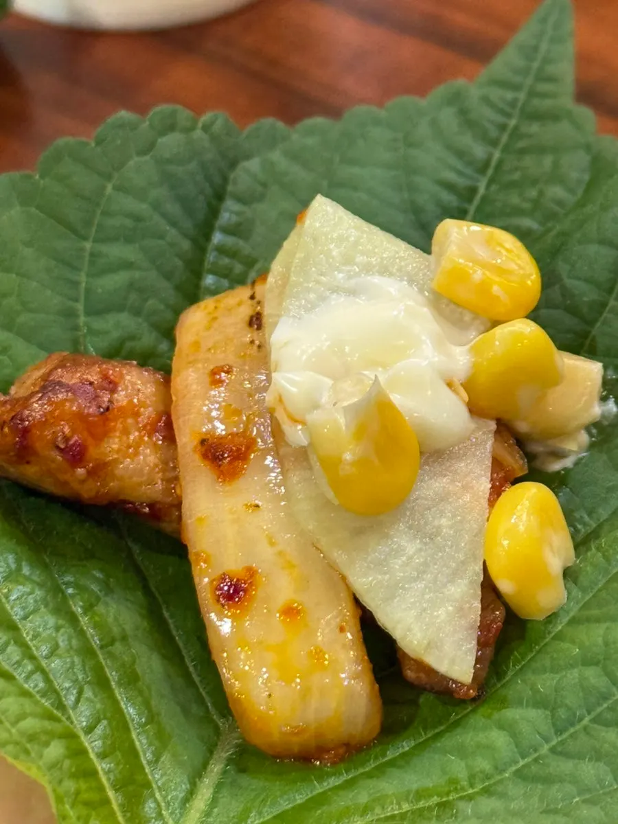 Sarangjip's side dishes including perilla leaves, corn mayo and pickled radish