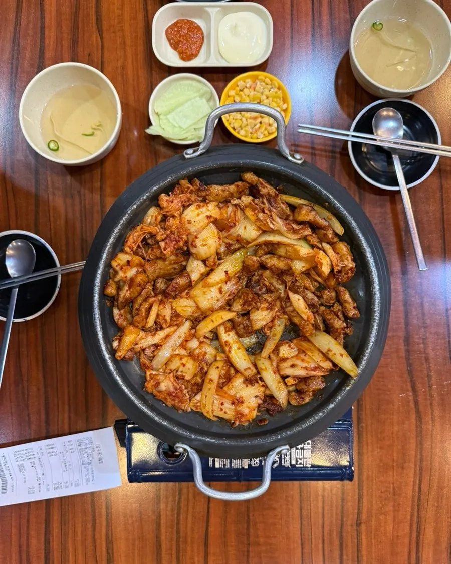 A wrap of perilla leaf with pork kimchi grill and corn on top