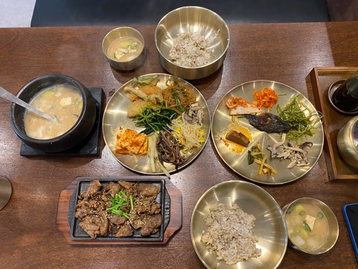 A barley rice meal with neatly prepared self-serve side dishes