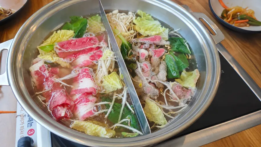 Pot of shabu-shabu broth cooking beef