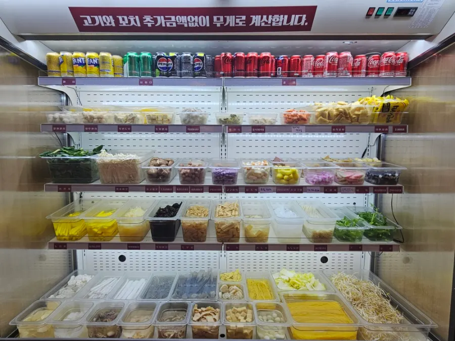 Sign listing side dishes like guobaorou and lemon cream shrimp