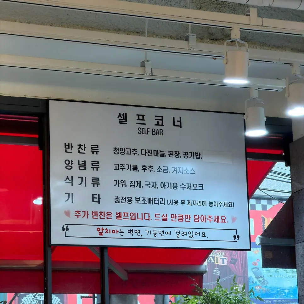 식기류와 일회용 앞치마가 놓인 셀프바