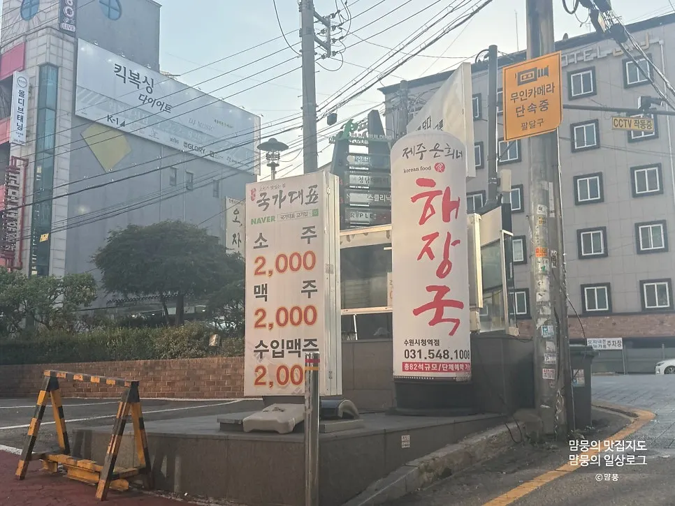 길가에 세워진 제주은희네해장국 수원시청역점 배너