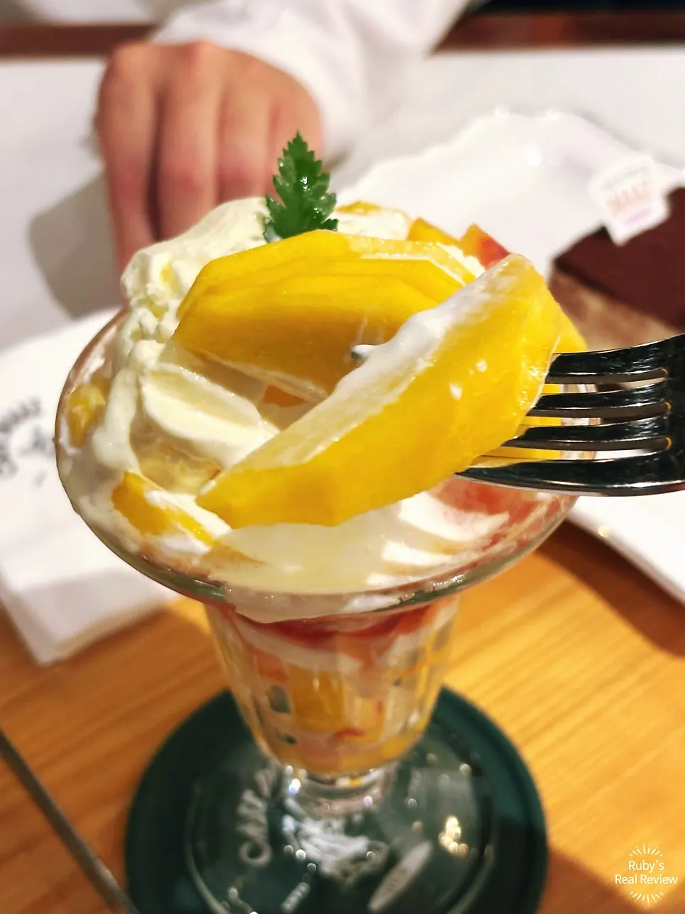Peach slices fanned out in a tall glass parfait
