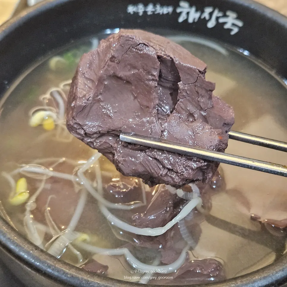 A springy piece of blood tofu lifted on a spoon
