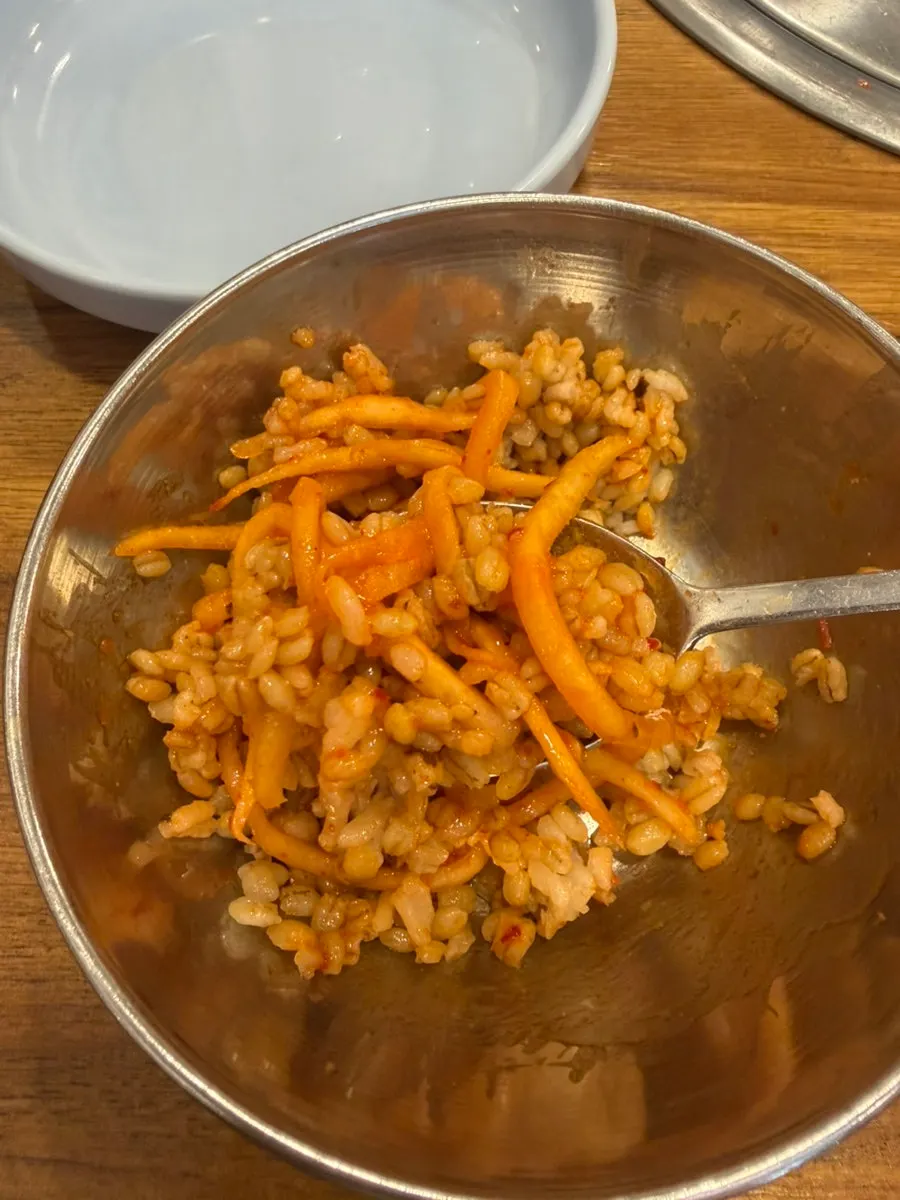 Barley rice being mixed with table gochujang