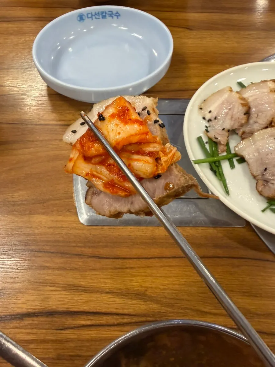 Bossam eaten with shredded radish on top