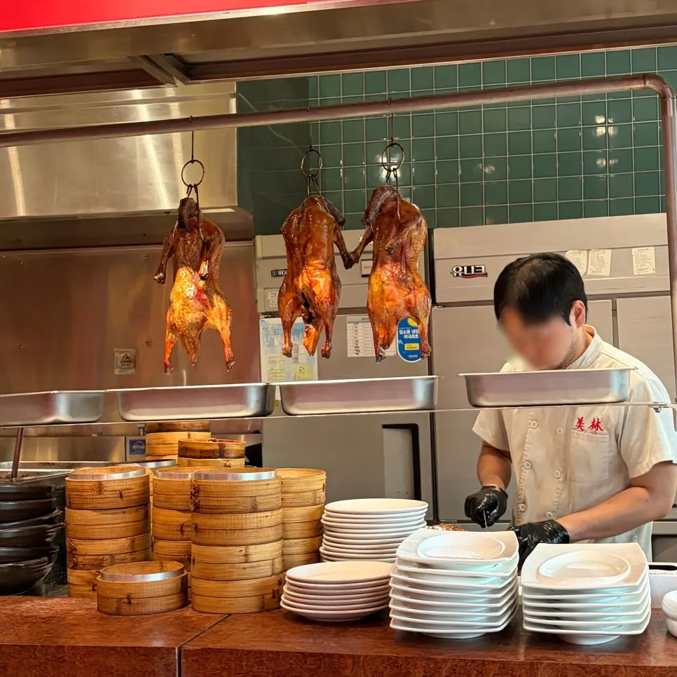 Roasted Peking ducks hanging in the open kitchen