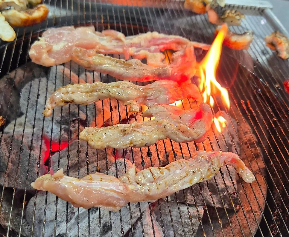 Homemade seasoned pork ribs grilling over charcoal