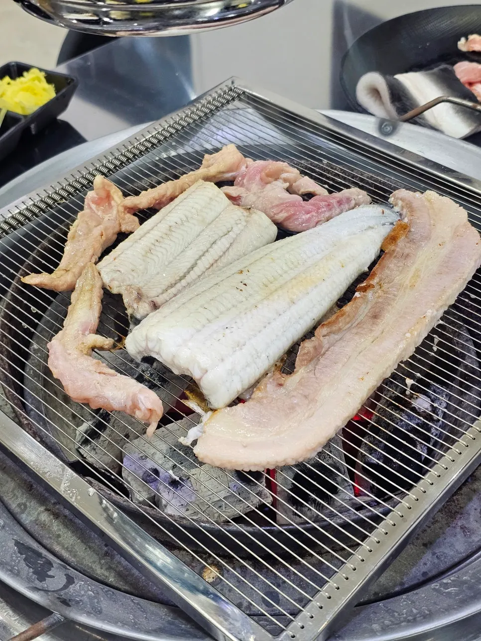 Freshwater eel grilling in the center of the charcoal grill