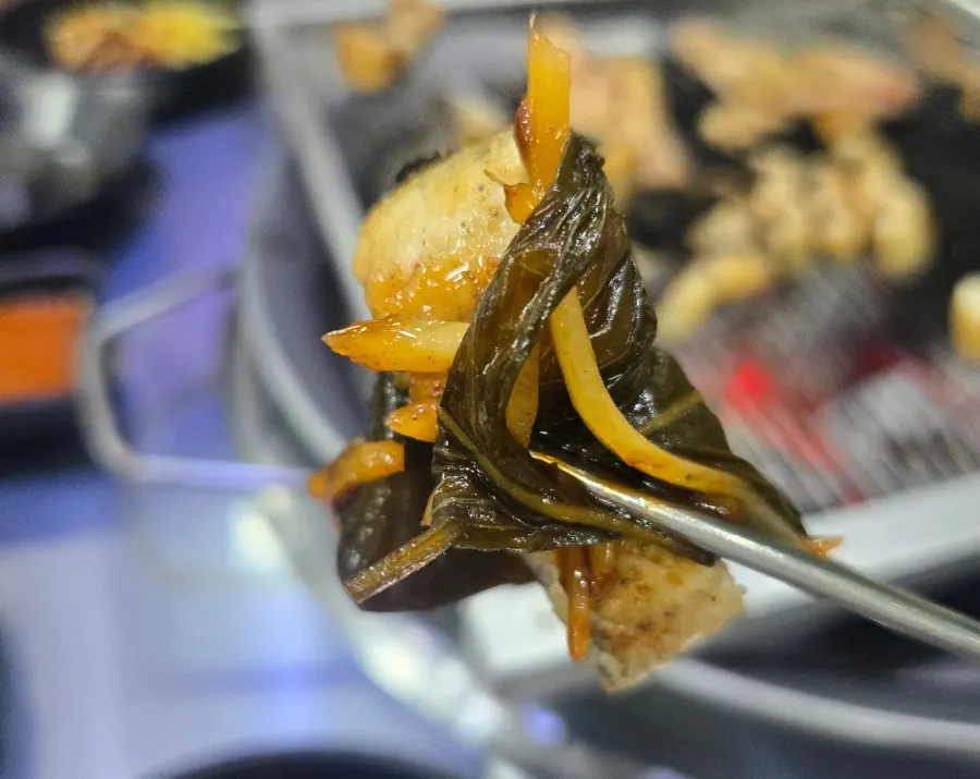 A piece of eel eaten wrapped in lettuce