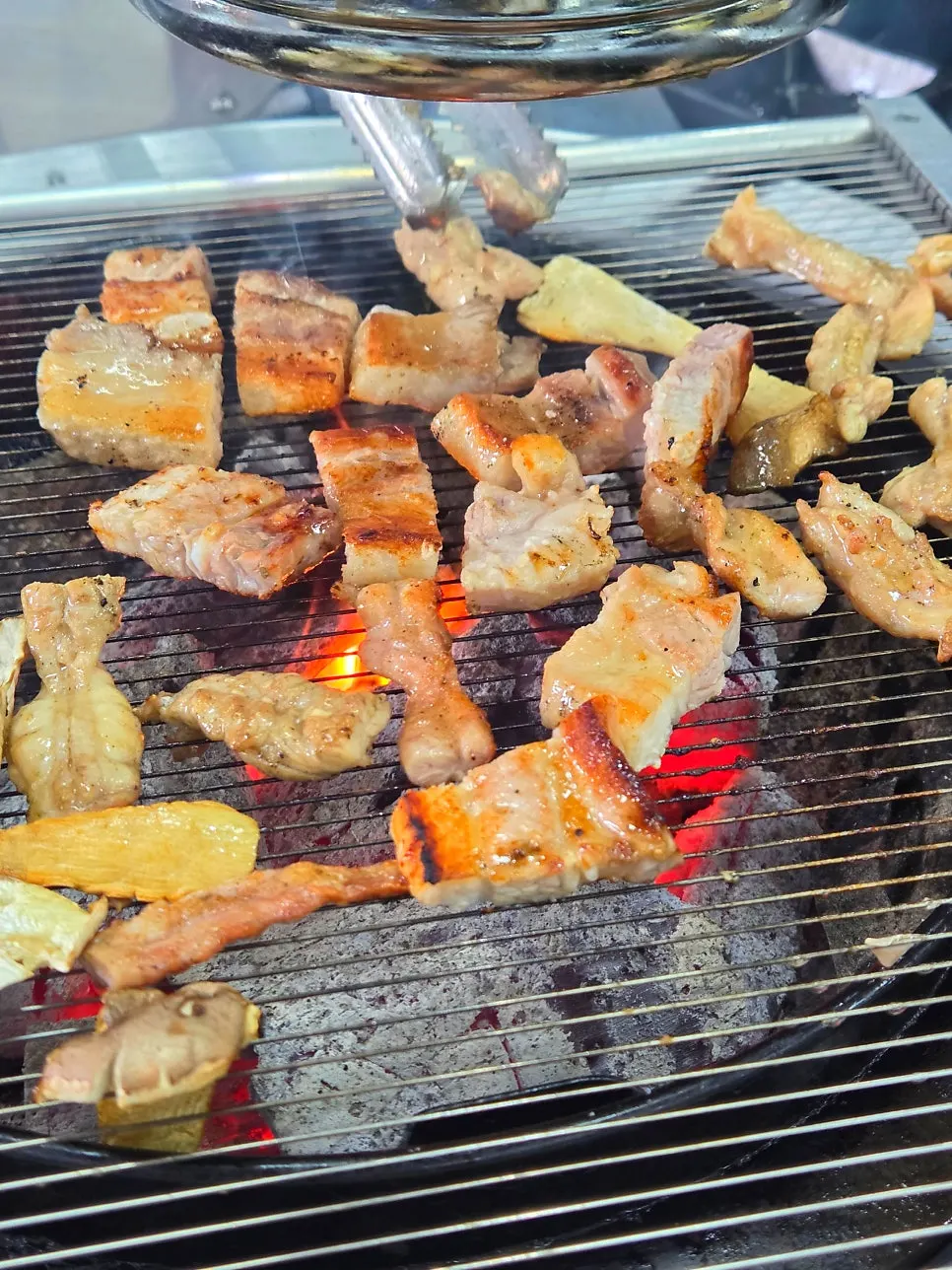 Pork belly and chicken neck meat grilling over charcoal