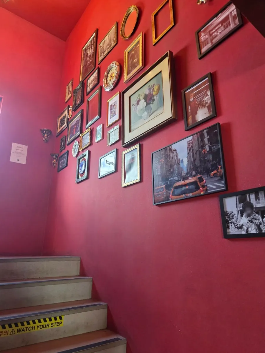 Staircase with photos hung along a red wall