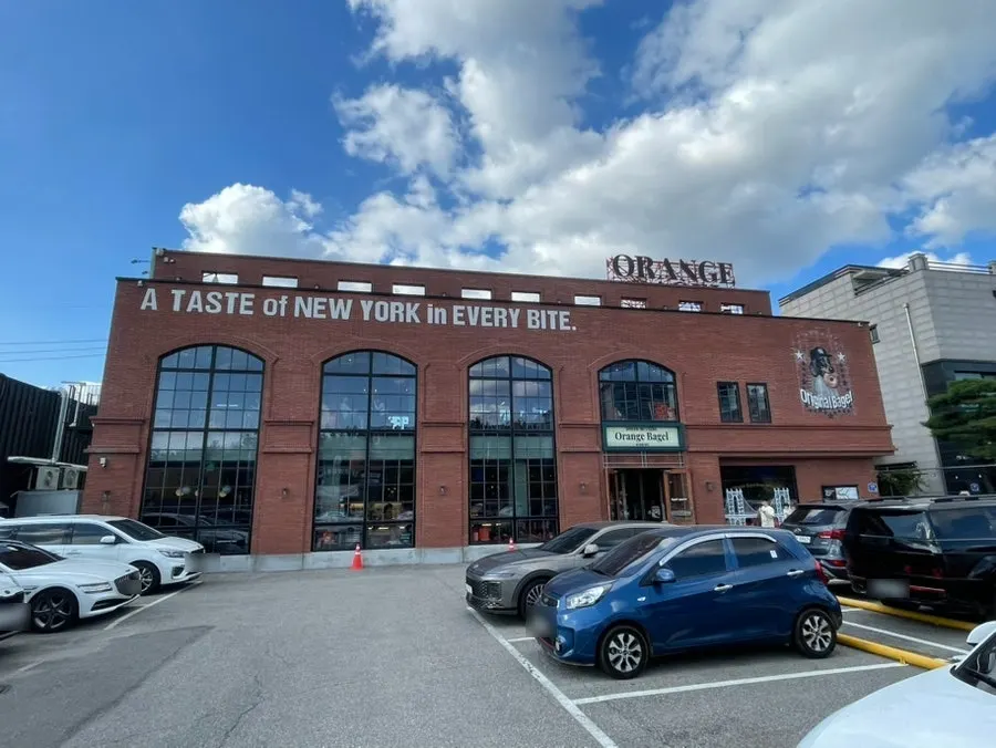 Full view of Orange Bagel's red-brick building exterior