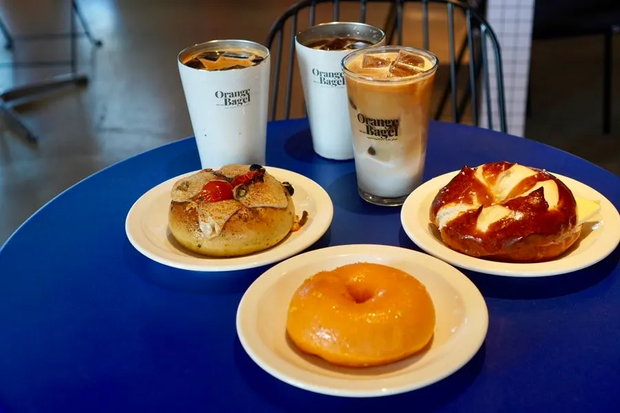 Table with three bagels, two Americanos, and a caffè latte