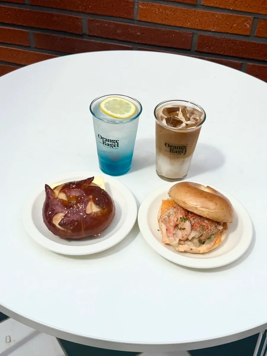 Table set with Orange Bagel bagels and drinks