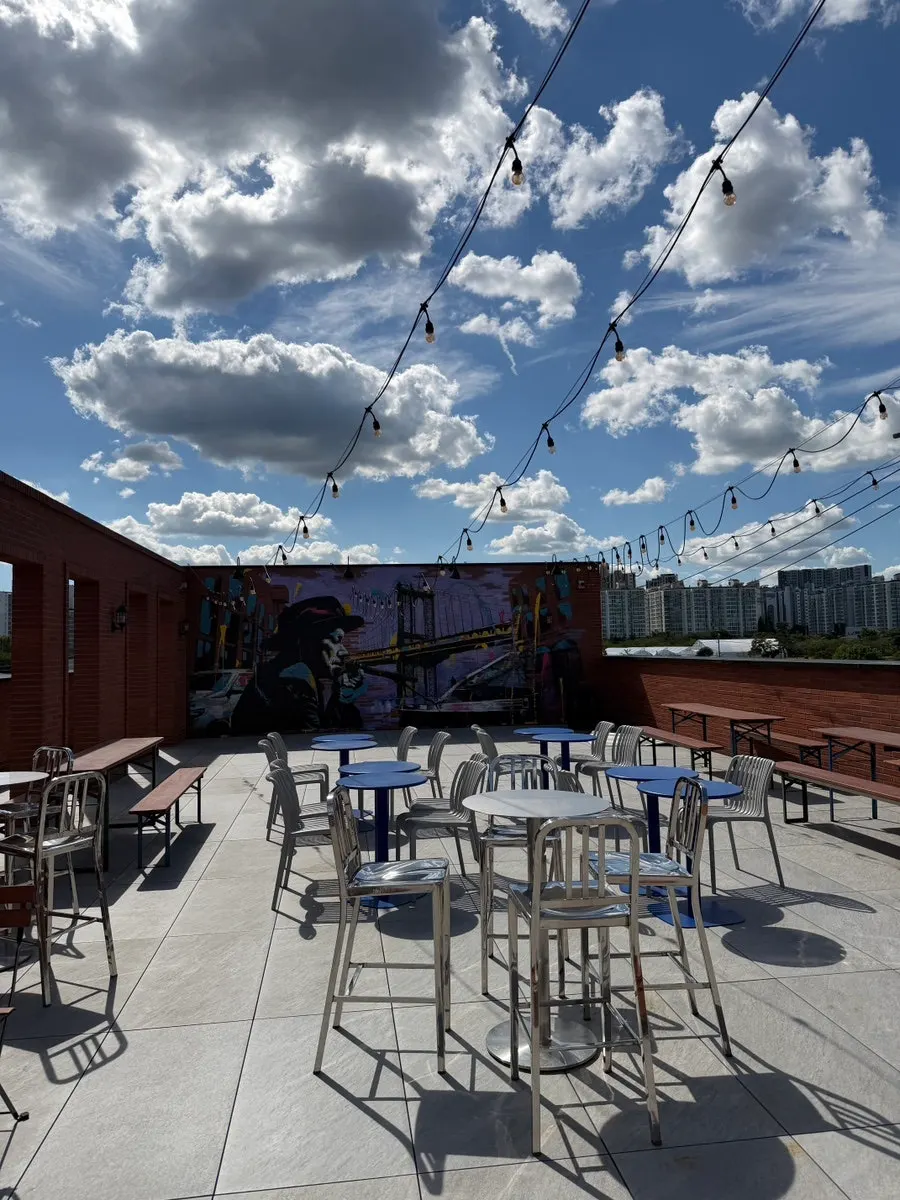 Outdoor terrace seating on the 3rd floor of Orange Bagel