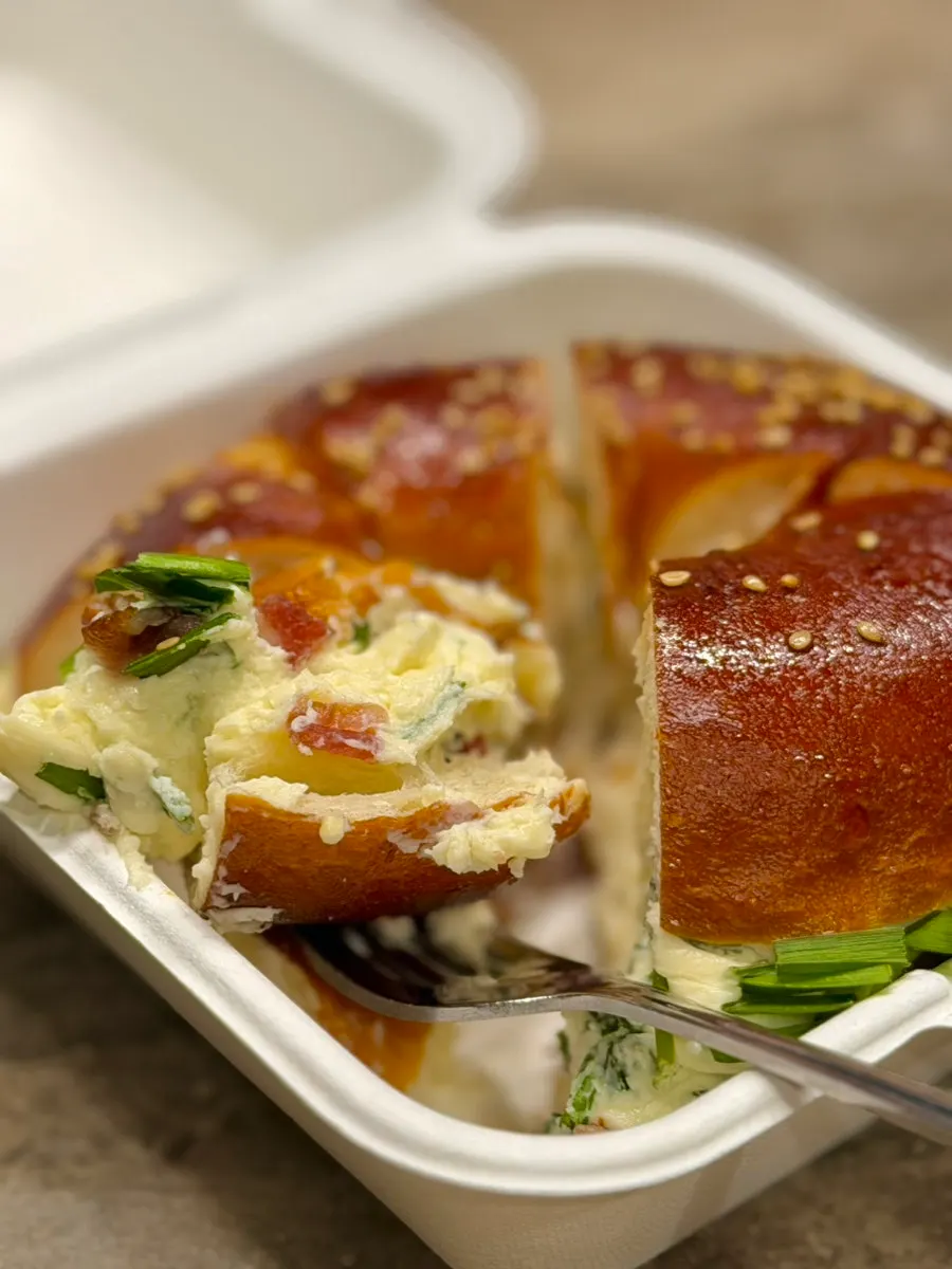 Cross-section of the scallion cream cheese bagel, packed with cream cheese
