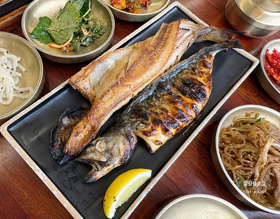 Full table spread with grilled fish and side dishes