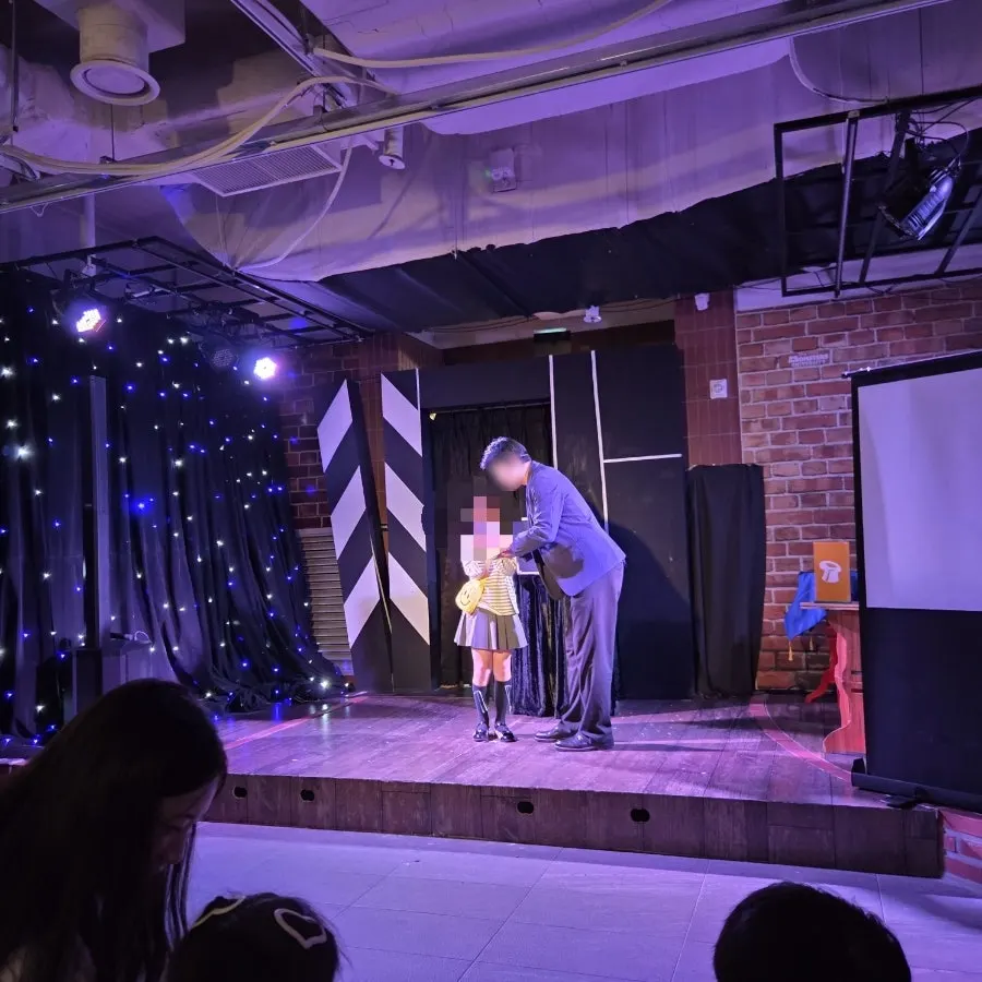 The magician appears as the curtain opens