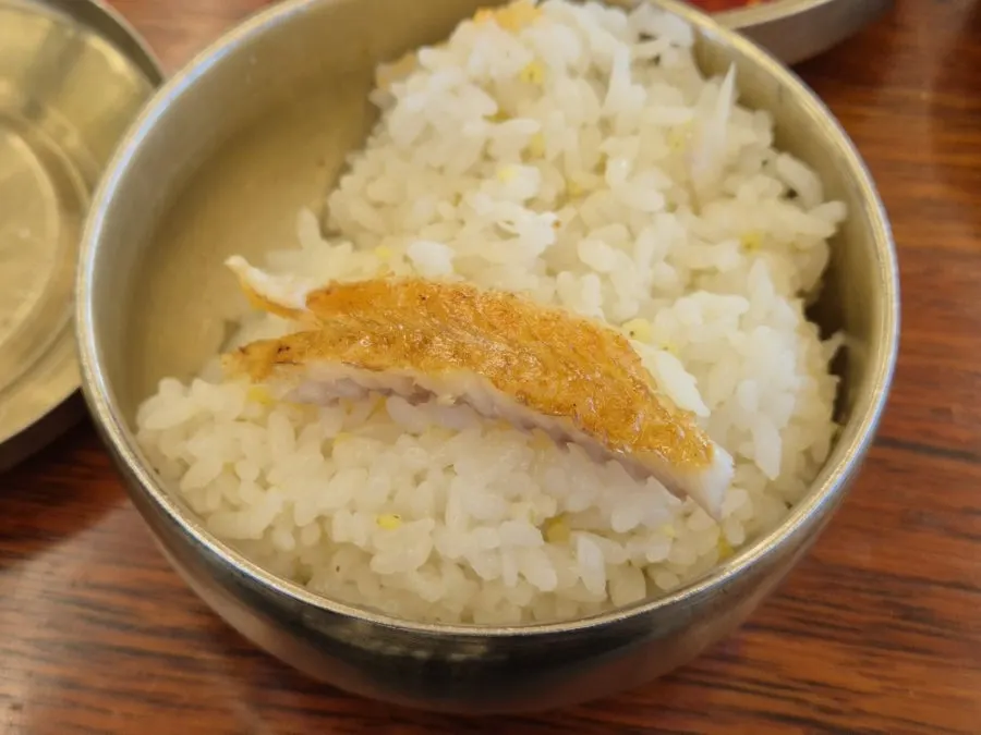 A spoonful of rice topped with fish flesh