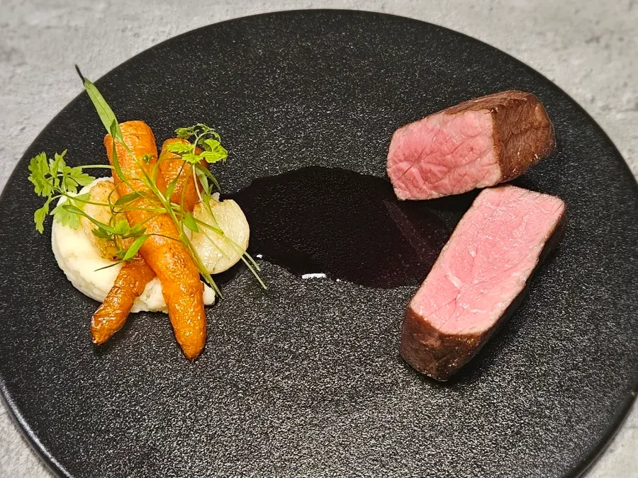 Chuck flap steak served with mini carrots and mashed potato
