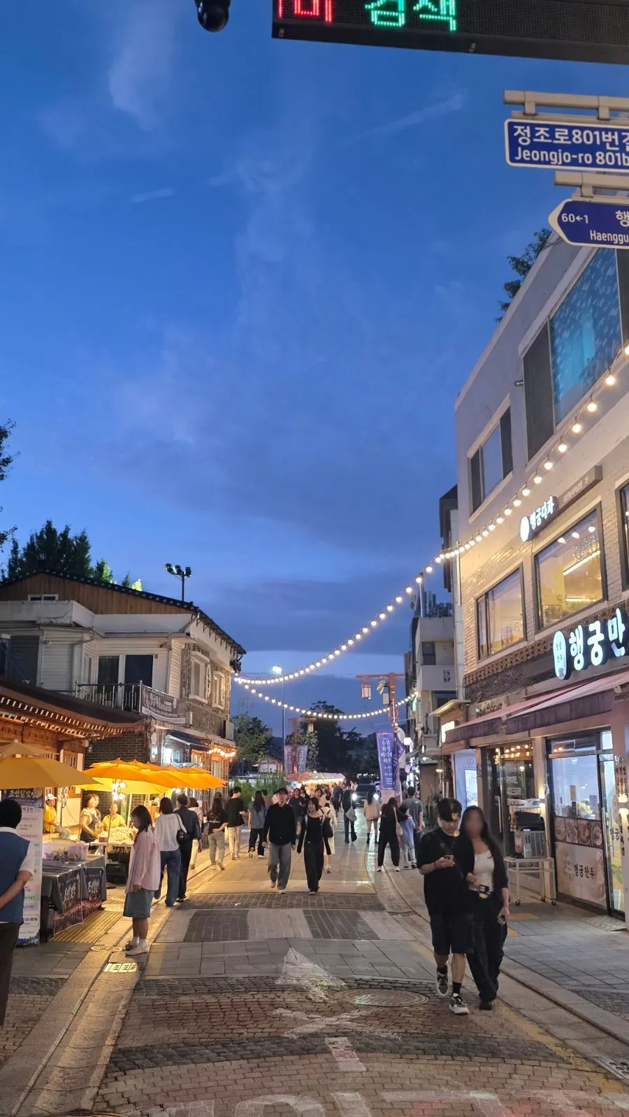 Vertical photo of the trinket shops lined along the Joseon Moonlight Market street