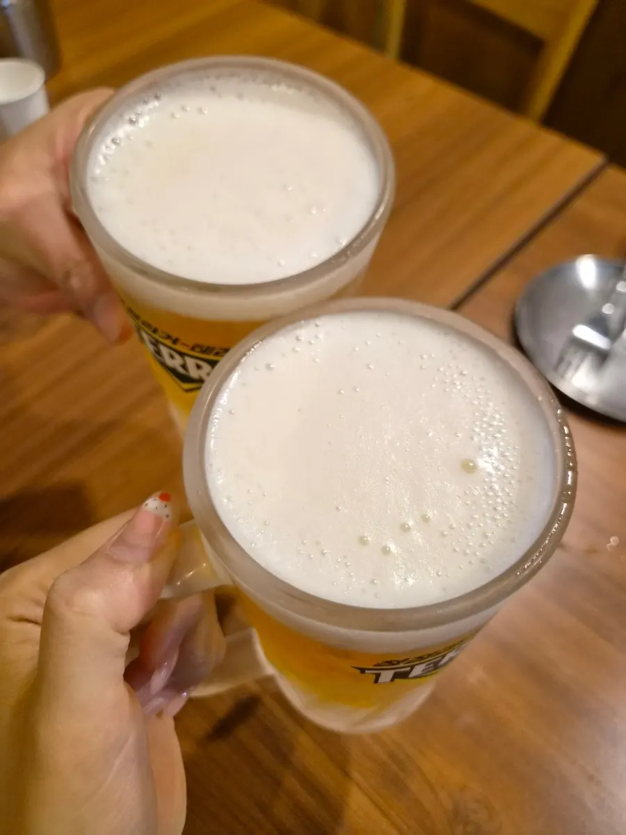 생맥주 잔과 기본 반찬이 놓인 테이블