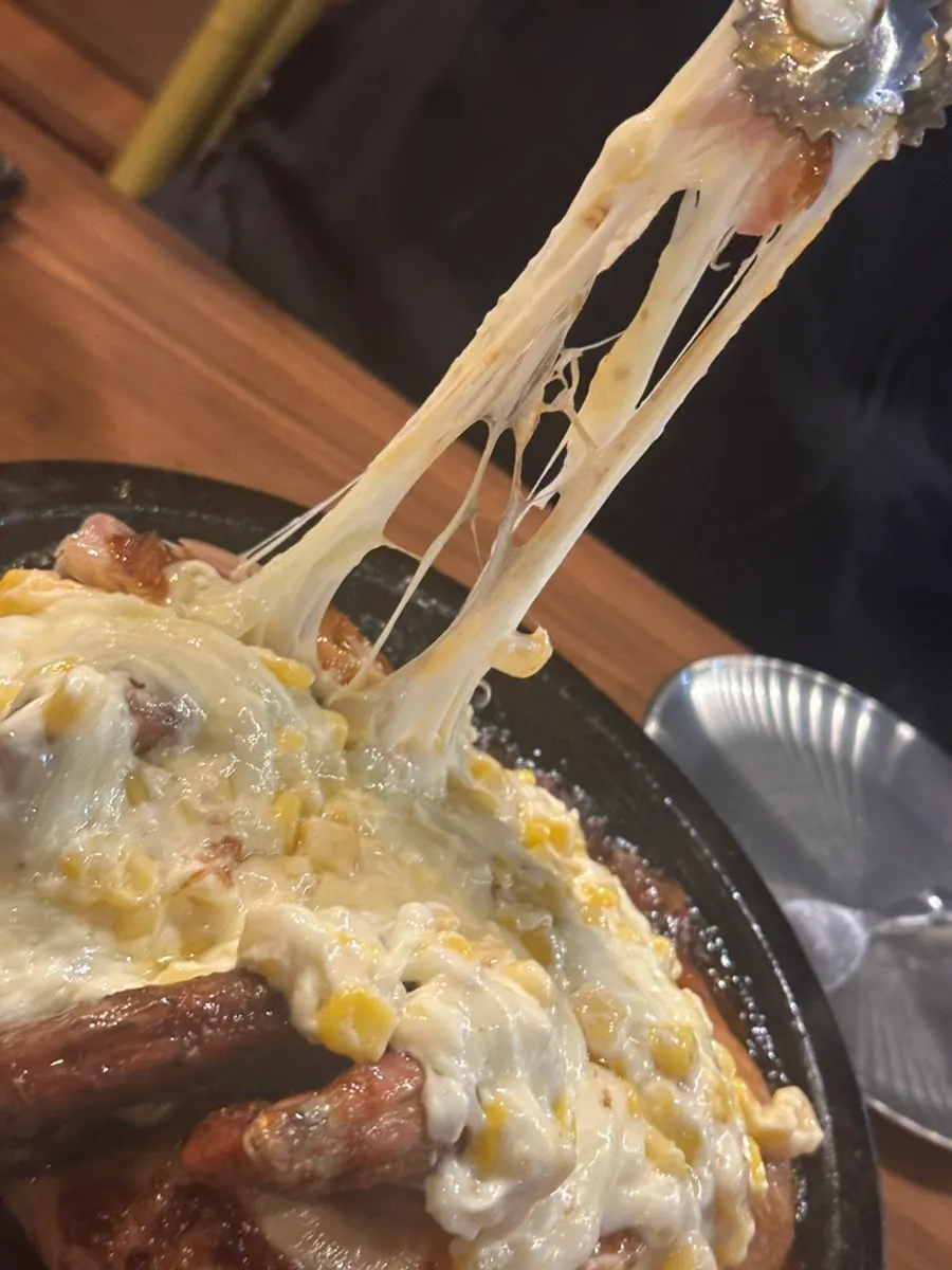 Stretchy corn cheese over the seasoned chicken