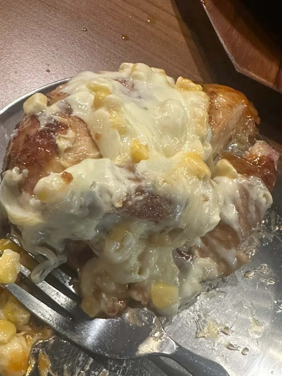 Hot stone plate still topped with leftover corn cheese near the end of the meal
